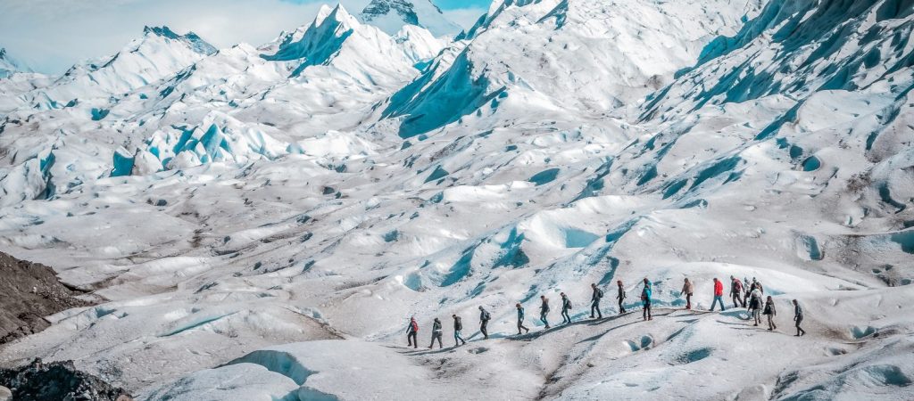 A line of tourists trekking on glacier at the Perito Moreno Glacier, El Calafate, Patagonia, Argentina, on a sunny but cloudy day. Perito Moreno Glacier is one of the largest glaciers in the Patagonian ice field. In addition to its accessibility, it is also one of the few glaciers in the world that are actively advancing. The glacier begins at the Andes Mountains bordering Argentina and Chile.